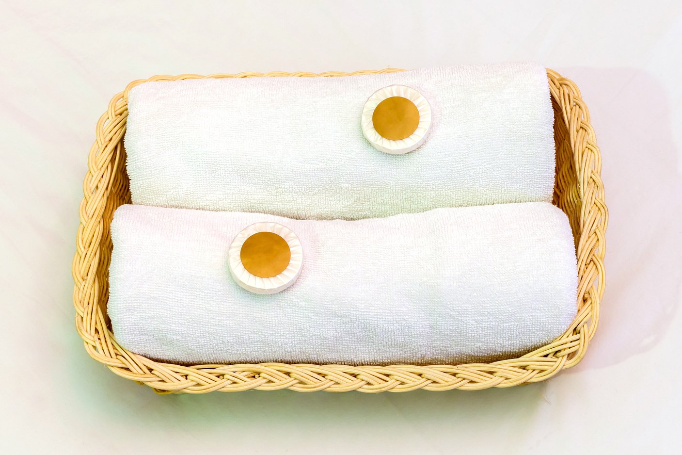 Two white towels and small soaps in wicker basket, good accommodation of hotel service.